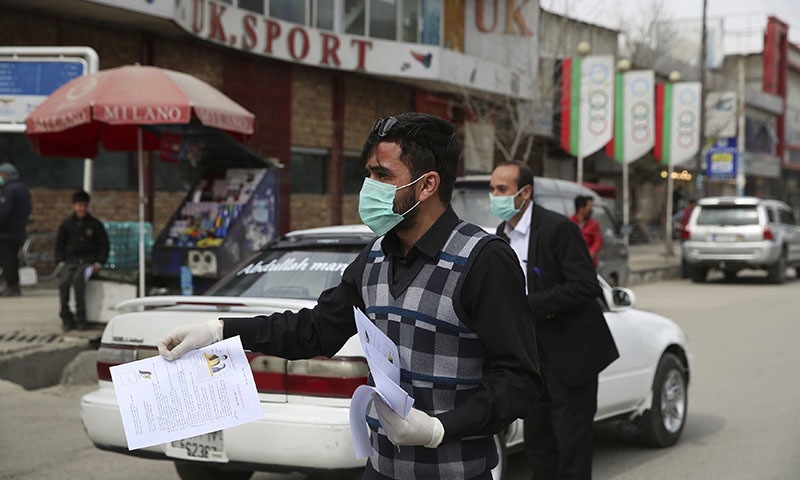 Civil society activists distribute written information to drivers during a campaign raise awareness of the new coronavirus in Kabul, Afghanistan, Monday, March 16, 2020. For most people, the new coronavirus causes only mild or moderate symptoms. For some it can cause more severe illness. (AP Photo/Rahmat Gul) &mdash; Copyright 2019 The Associated Press. All rights reserved.