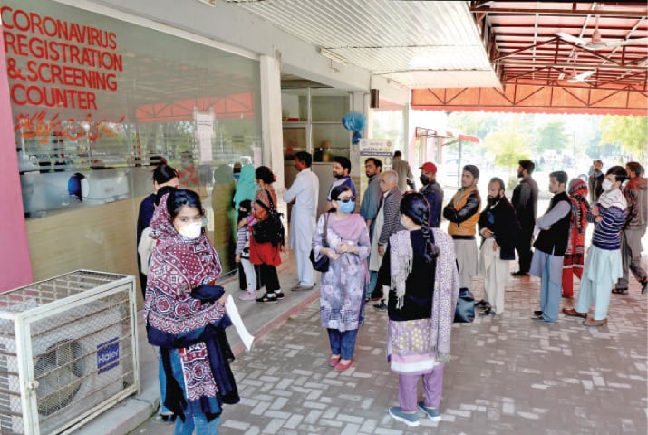 People queue at a counter to get themselves tested for COVID-19 at Pims in Islamabad on Monday. — Photo by Mohammad Asim