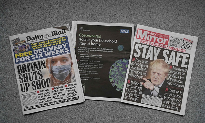 An arrangement of UK daily newspapers photographed as an illustration in Liverpool on March 17, 2020, shows front page headlines and a back page NHS advisory, reporting on the story that Britain is stepping up its response to coronavirus, recommending household isolation, home-working and an end to mass gatherings to try to stem an accelerating outbreak. — AFP