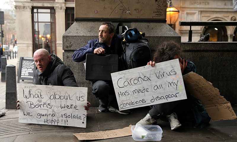 A homeless man holds a sign reading "What about us Boris — were we gunna isolate? Help!", relating to the UK government's advice to self-isolate if a person has covid-19 symptoms, in London, on March 19, 2020. Britain announced Wednesday it would be closing schools in the coming days and placing 20,000 troops on standby in efforts to stem the spread of coronavirus, as the death toll topped 100. — AFP