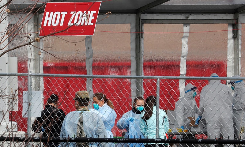 Health workers in personal protective equipment (PPE) work inside a new drive-thru coronavirus testing centre in the Staten Island borough of New York City, New York, US on March 19, 2020. — Reuters