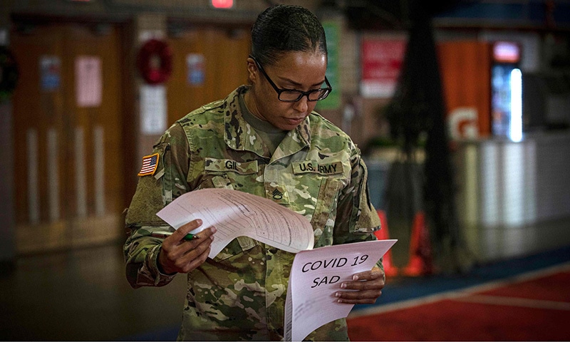 In this photo released by the US Defense Department, a New Jersey Army National Guard Soldier looks over paperwork during in-processing and medical screening for state activation at the Teaneck Armory in Teaneck, New Jersey on March 19, 2020. The New Jersey National Guard has more than 150 members activated to support state and local authorities during the COVID-19 outbreak. &mdash;AFP