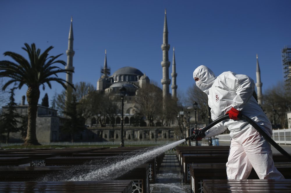 A municipality worker wearing a face mask and protective suits disinfects chairs outside the the historical Sultan Ahmed Mosque, also known as Blue Mosque, amid the coronavirus outbreak, in Istanbul on Saturday. — AP