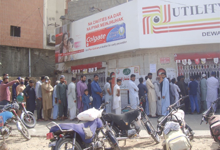 Karachi: Buyers wait for their turn outside a Utility Store at Gizri Boulevard. Prices of essential kitchen items have gone up considerably in super stores across the city, forcing many people to opt for shopping at government stores.—Photo by the writer