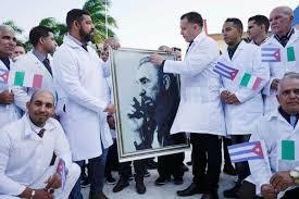 Cuban doctors hold an image of late Cuban President Fidel Castro during a farewell ceremony before departing to Italy to assist amid concerns about the spread of the coronavirus disease outbreak, in Havana, Cuba. &mdash;Reuters