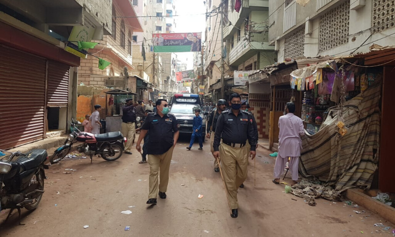 Police officers walking through the Kalapul Hazara Colony area in Karachi. &mdash;Police sources