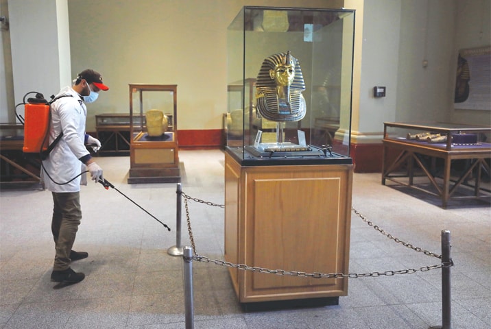 CAIRO: A member of a medical team sprays disinfectant near the golden mask of King Tutankhamun at the Egyptian Museum as a precautionary move against coronavirus.—Reuters