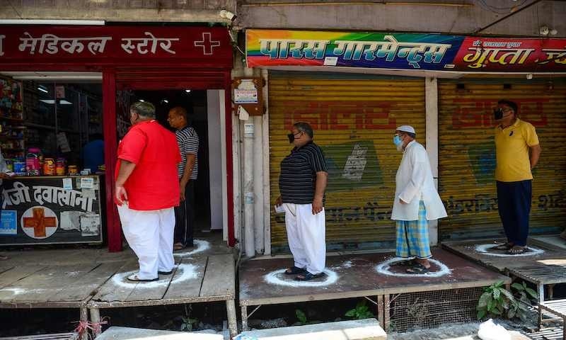 People stand on designated areas to maintain social distancing as they queue outside a medical store during the first day of a 21-day government-imposed nationwide lockdown as a preventive measure against the coronavirus in Allahabad on March 25, 2020. &mdash; AFP