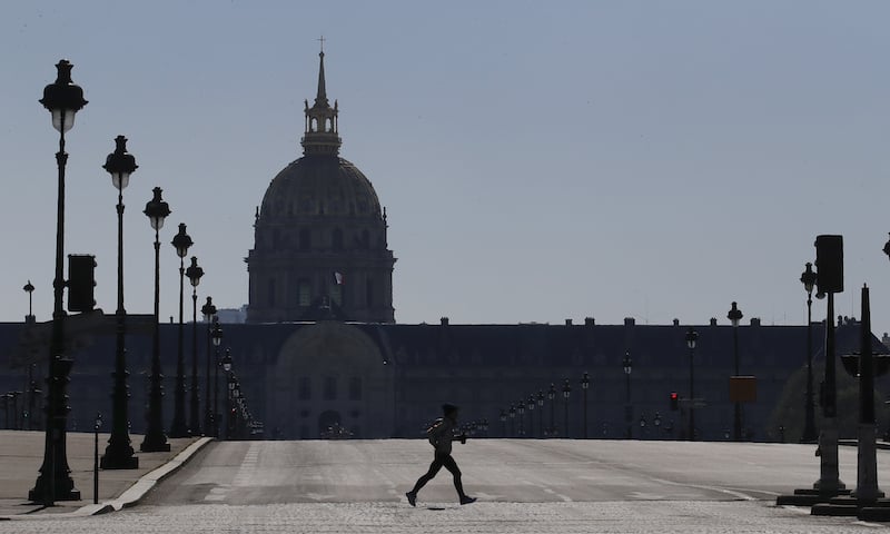 A man jogs in an empty Paris street on Wednesday, March 25, 2020. French President Emmanuel Macron urged employees to keep working in supermarkets, production sites and other businesses that need to keep running amid stringent restrictions of movement due to the rapid spreading of the new coronavirus in the country. &mdash; AP