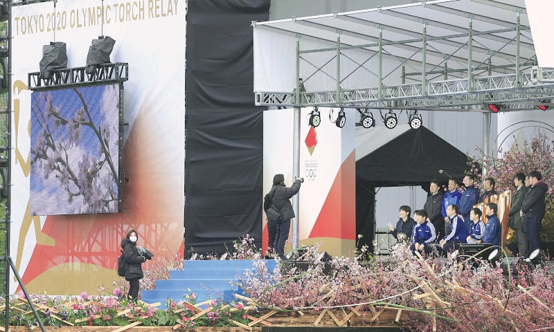 OFFICIALS take souvenir photos on Wednesday next to the Olympic cauldron as they start to remove the decorations at J-Village, a national football training centre in Naraha Town, Fukushima Prefecture, where the Olympic Torch Relay was supposed to start from.&mdash;Reuters