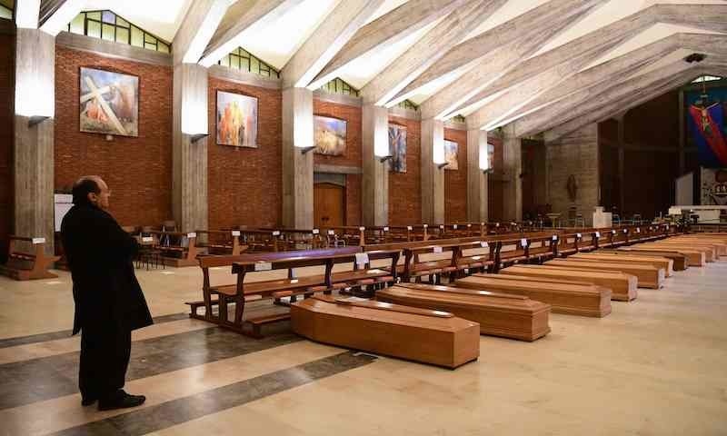 Parish priest of Seriate, Don Mario stands by coffins stored into the church of San Giuseppe in Seriate, near Bergamo, Lombardy in Italy on March 26, 2020, during the country's lockdown following the new coronavirus pandemic. &mdash; AFP