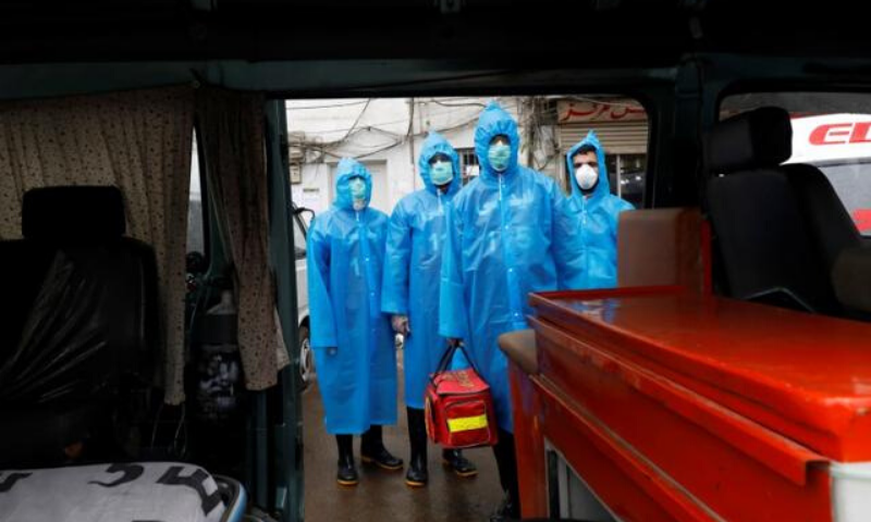 Volunteers of the Edhi Foundation wear raincoats and boots as they pose during a mock drill on handling suspected carriers of the coronavirus disease in Karachi. —Reuters