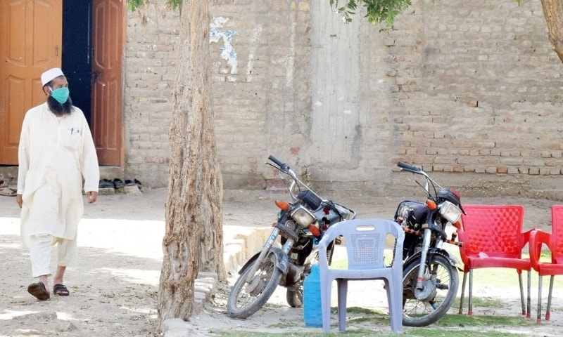 Wearing mask a member of Tableeghi Jamaat comes out of the main hall of Makki Mosque in Sehrish Nagar. —  Umair Ali