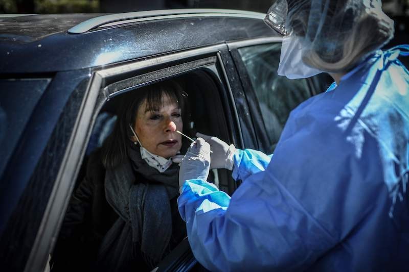 A nurse collects a sample from a person at a COVID-19 screening station outside the district hall of the 17th arrondissement in Paris, on March 30, 2020, on the fourteenth day of a lockdown aimed at curbing the spread of the novel coronavirus in France. — AFP