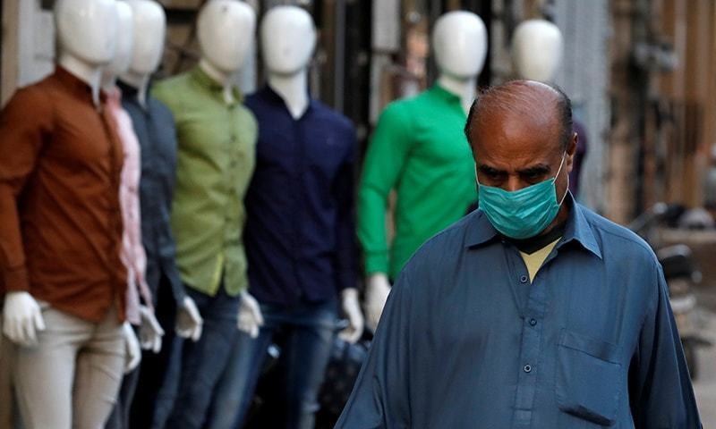 A man wears a face mask as a preventive measure walks in a market Karachi on March 3. — Reuters/File