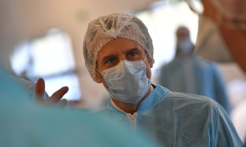 French President Emmanuel Macron wearing a protective suit and a face mask visits the Kolmi-Hopen protective face masks factory. &mdash;Reuters