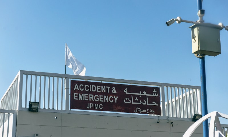 A YOUNGSTER recites Azan on a rooftop and a white flag (right) is installed atop a healthcare facility.—Fahim Siddiqi / White Star