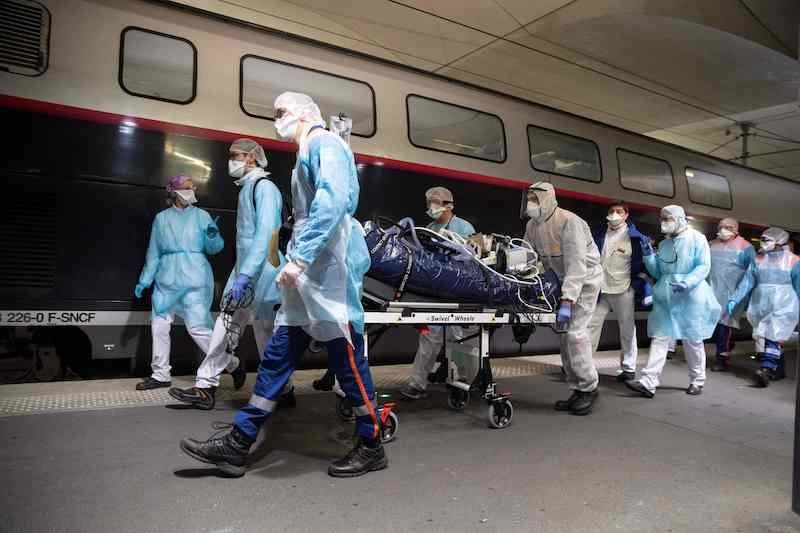 Medical staff carry a patient infected with the COVID-19 into a TGV high speed train at the Gare d'Austerlitz train station on April 1, 2020 in Paris, prior to his evacuation, along with 35 other patients in two separate medical TGV towards hospitals of Brittany, western France, where the outbreak of the Covid-19 pandemic caused by the novel coronavirus where  has been limited so far. (Photo by Thomas SAMSON / POOL / AFP) &mdash; AFP or licensors