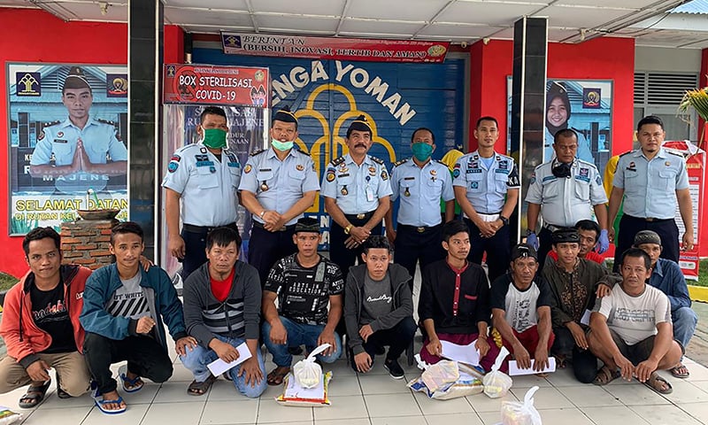 Inmates (front) pose for a photo with prison officials after they were released in Majene. — AFP/INDONESIAN MINISTRY OF LAW AND HUMAN RIGHTS