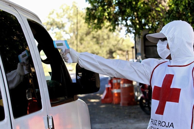 A member of the Red Cross checks the temperature of person onboard a vehicle as a preventive measure against the spread of the new coronavirus on the highway to Puerto Vallarta, in Zapopan, Jalisco state, Mexico, on April 7, 2020. &mdash; AFP