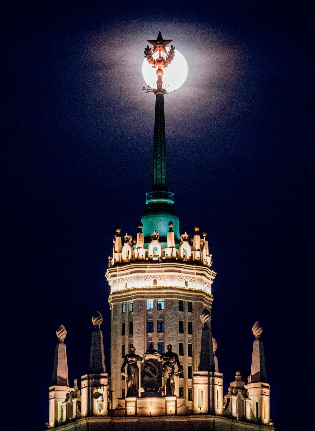 A picture taken on April 7 shows the closest supermoon to the earth, also known as pink moon, behind the top of a Stalin-era skyscraper seen in downtown Moscow. — AFP