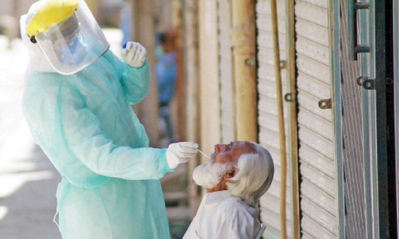 A medical staff member takes a swab of a resident of Tramri in Islamabad on Friday. The district magistrate had directed sealing of Tramri Chowk after Covid-19 positive cases were reported in the area. Capital police, Rangers and the army have been asked to cordon off the area. — Online A medical staff member takes a swab of a resident of Tramri in Islamabad on Friday. The district magistrate had directed sealing of Tramri Chowk after Covid-19 positive cases were reported in the area. Capital police, Rangers and the army have been asked to cordon off the area. — Online