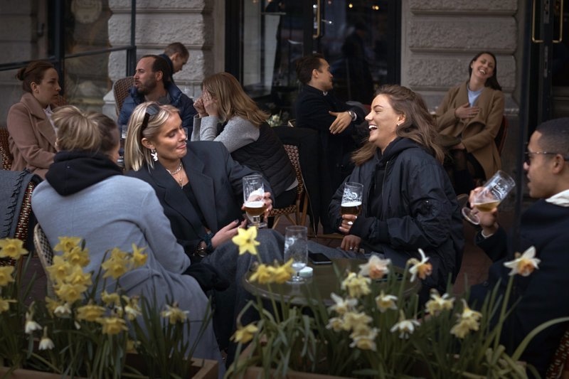 In this April 8 file photo people chat and drink outside a bar in Stockholm, Sweden. — AP