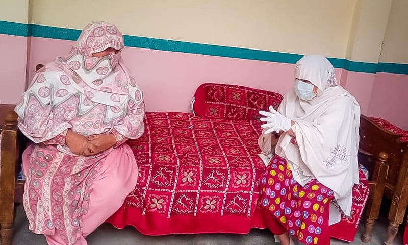 A healthcare worker shows preventive measures to a woman. — Photo by author