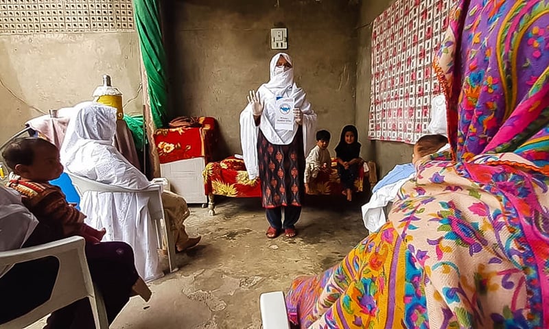 A lady health worker informs women about social distancing. — Photo by author