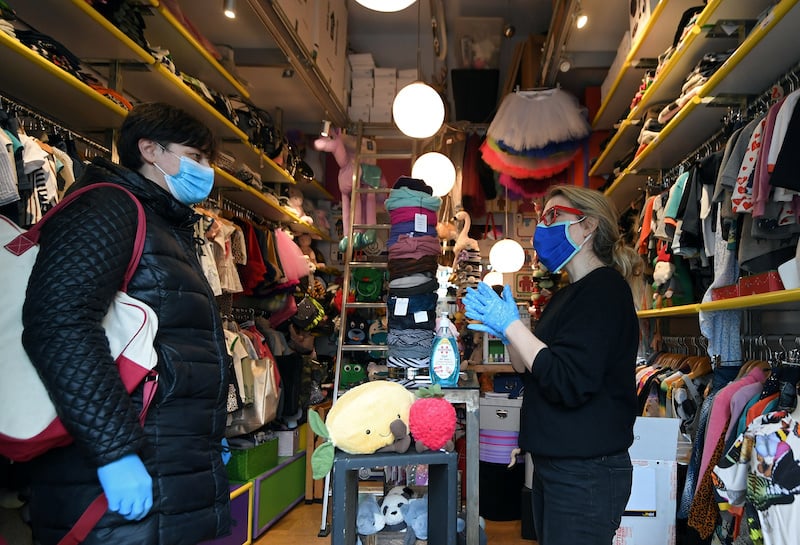 A client wearing a face mask consults the vendor of a children's store in Rome's Trastevere district as the Italian government allows the reopening of some shops while a nationwide lockdown continues, following the outbreak of coronavirus disease (COVID-19) in Rome, Italy, April 14, 2020. REUTERS/Alberto Lingria