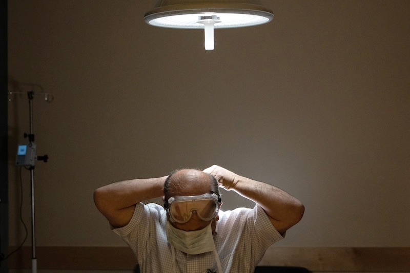 Bassam Betarske, a 61-year-old ER doctor who deals directly with the coronavirus disease (COVID-19) patients, removes his PPE at the end of his shift at Van Wert County Hospital in Van Wert, Ohio, U.S., April 4, 2020. Picture taken April 4, 2020.  REUTERS/Megan Jelinger NO RESALES. NO ARCHIVES