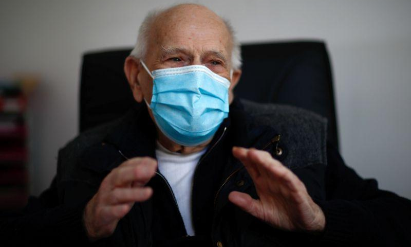 French doctor Christian Chenay, 98 year-old, wearing a protective face mask, sits in his consulting room at the doctor's office in Chevilly-Larue near Paris. — Reuters