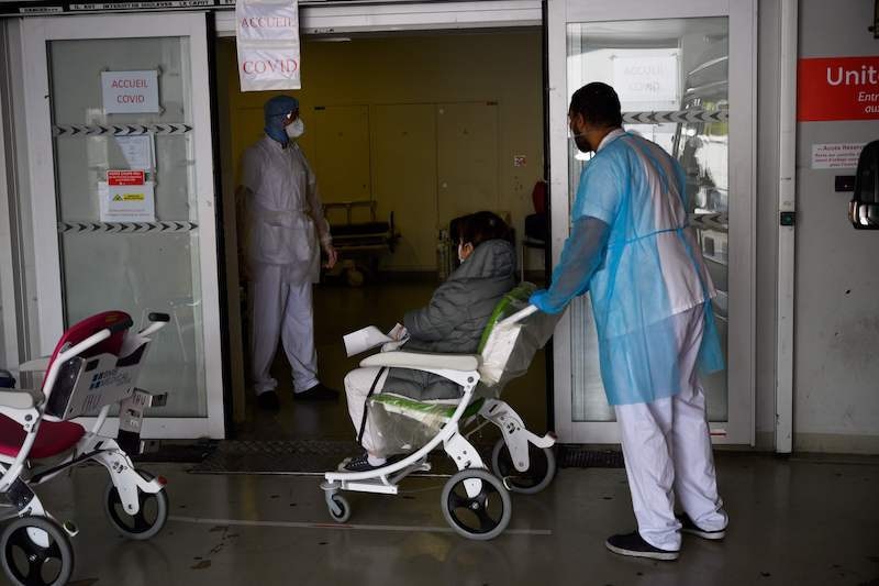 A medical staff member pushes a woman suspected of being infected with Covid-19, into a Covid-19 unit at the Timone Hospital in Marseille, southeastern France, on April 15, 2020, on the 30th day of a lockdown in France aimed at curbing the spread of the pandemic. — AFP