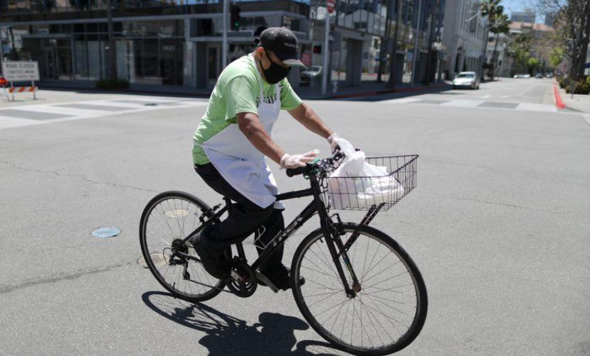 A food delivery driver cycles on an empty road as the global outbreak of Covid-19 continues, in Beverly Hills, California, US, April 15. — Reuters