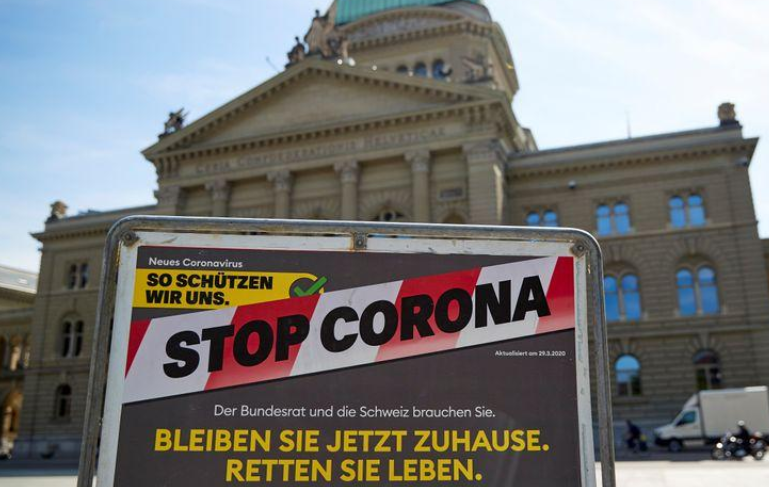 A sign is pictured in front of the Swiss Parliament Building (Bundeshaus) during a federal council meeting on the outbreak of Covid-19 in Bern, Switzerland, April 16. &mdash;Reuters