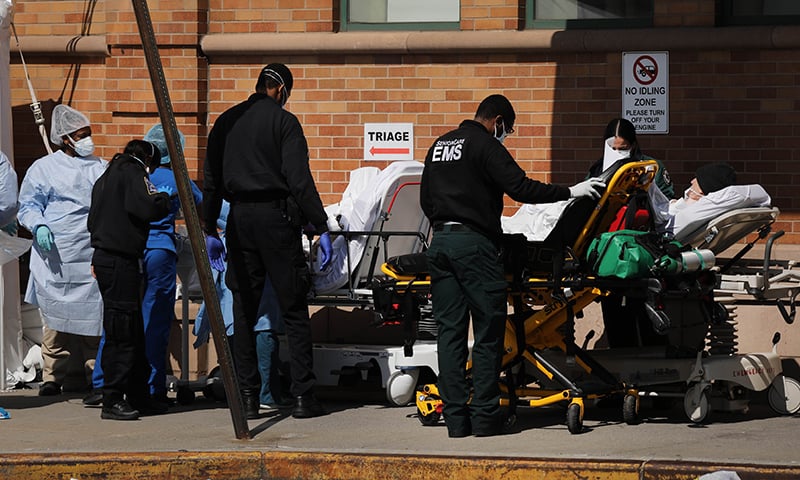Medical workers work with numerous patients outside a special coronavirus intake area at Maimonides Medical Centre on April 16 in the Brooklyn borough of New York City. &mdash; AFP
