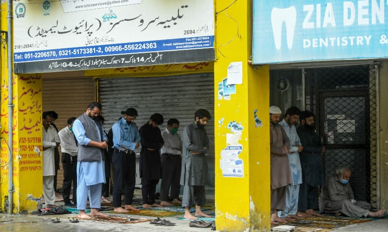 People offer Friday prayers outside a mosque in Islamabad despite a lockdown. &mdash; AFP