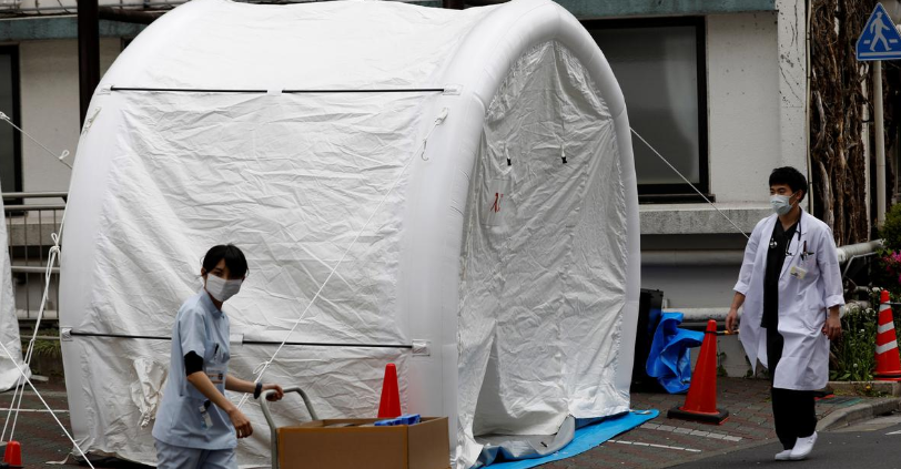 Medical workers walk by tents set up to test for Covid-19 infection at Kawakita General Hospital in Tokyo, Japan, April 17. — Reuters