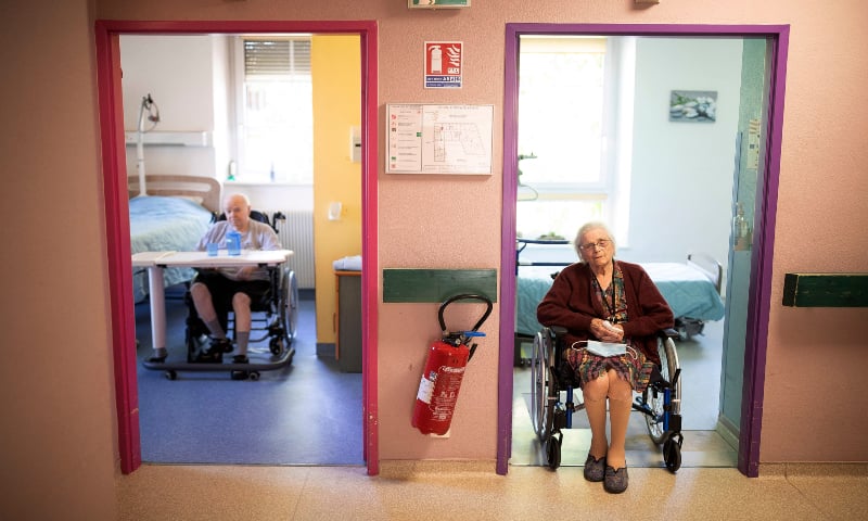 Marie Lithard, right, and her neighbour Yves Chretien sit looking out of their rooms in a nursing home in Ammerschwir, France. &mdash; AP