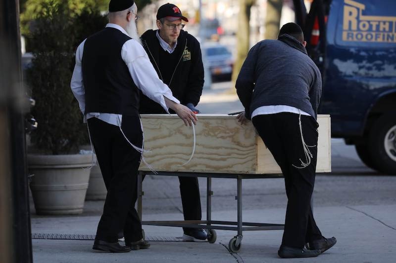 NEW YORK, NY - APRIL 19: A casket is moved to a van outside of a funeral home in the heavily Orthodox Borough Park neighborhood of Brooklyn which has scene a large number of deaths due to the coronavirus on April 19, 2020 in New York City. Hospitals in New York City, which have been especially hard hit by the coronavirus, are just beginning to see a slowdown of COVID-19 cases.   Spencer Platt/Getty Images/AFP
== FOR NEWSPAPERS, INTERNET, TELCOS & TELEVISION USE ONLY ==