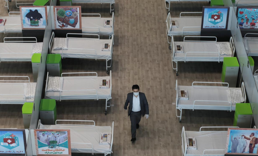 A man walks between beds at a shopping mall, one of Iran's largest, which has been turned into a centre to receive patients suffering from Covid-19, in Tehran on April 4. &mdash; Reuters