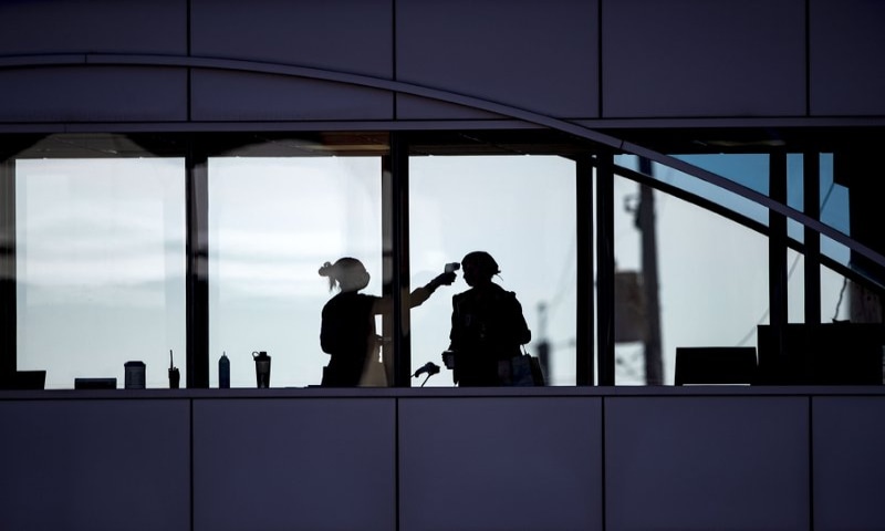 In this Friday, April 10, 2020 photo, amid coronavirus concerns, a healthcare worker takes the temperature of a visitor to Essentia Health who was crossing over a skywalk bridge from the adjoining parking deck, in Duluth, Minnesota. — AP In this Friday, April 10, 2020 photo, amid coronavirus concerns, a healthcare worker takes the temperature of a visitor to Essentia Health who was crossing over a skywalk bridge from the adjoining parking deck, in Duluth, Minnesota. — AP