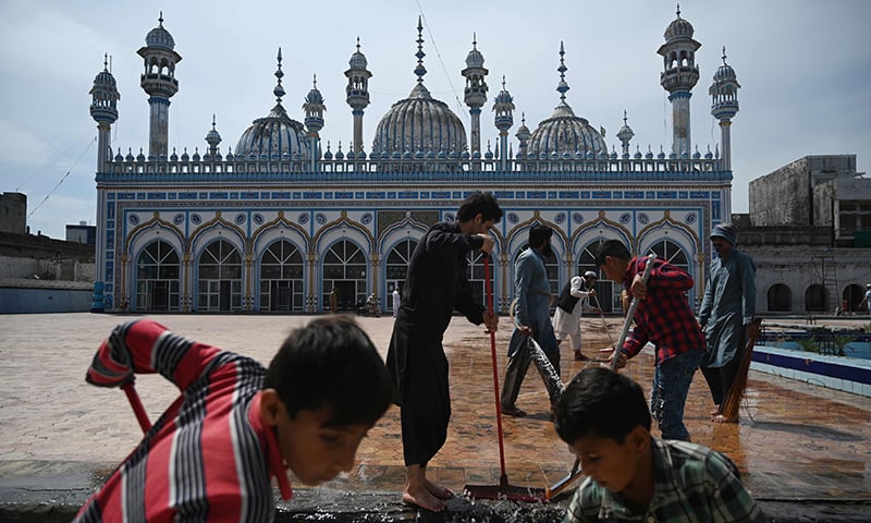 Devotees wash the floor of the Jamia Mosque ahead of Ramazan in Rawalpindi. &mdash; AFP