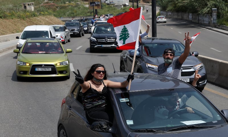 Anti-government protesters wave Lebanese flags from their cars as they protest by driving through the streets. &mdash; AP