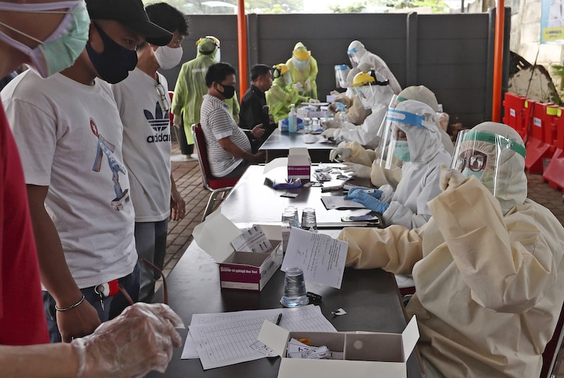 Indonesian men talk to a health worker as they wait for their turn to have their blood samples taken at a coronavirus rapid test site in Tangerang, Indonesia, on Tuesday, April 21, 2020. — AP
