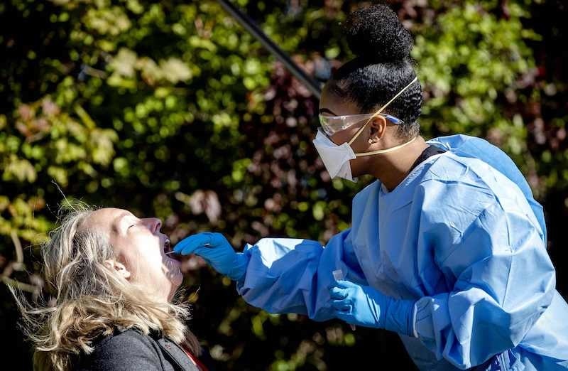 A healthcare personnel is tested for the coronavirus, at a mobile test site in Middelharnis, the Netherlands, on April 21, 2020. (Photo by Sem VAN DER WAL / ANP / AFP) / Netherlands OUT