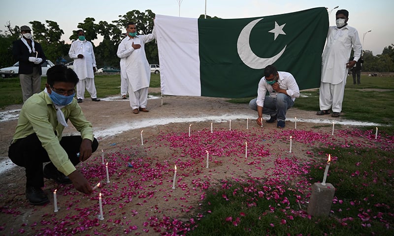 Activists of the minority wing of the ruling Pakistan Tehreek-i-Insaf lay candles as they pray asking for the end of the coronavirus pandemic in Islamabad on April 22. &mdash; AFP