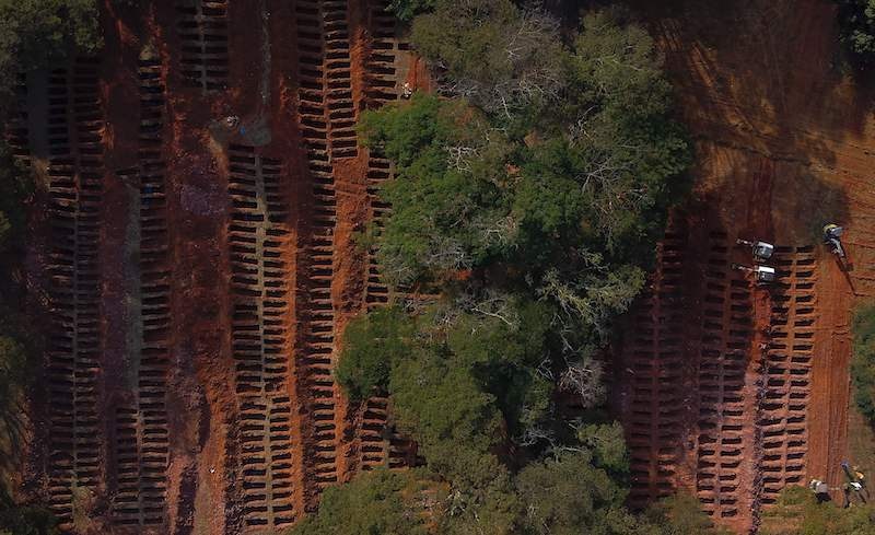 Aerial view of workers on backhoes digging graves in the Vila Formosa cemetery, due to an expected increase in deaths due to the coronavirus pandemic, in the city of Sao Paulo, Brazil, on 21 April 2020. — AFP