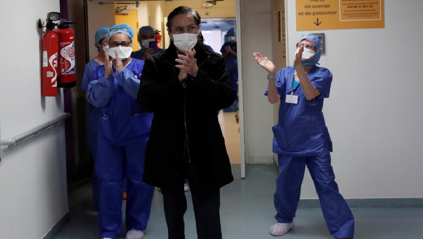 Medical staff members applaud patient Mang Phother, 61, who spent 16 days in the Intensive Care Unit (ICU) for Covid-19, as he leaves the Clinique de l'Estree private hospital in Stains near Paris. — Reuters