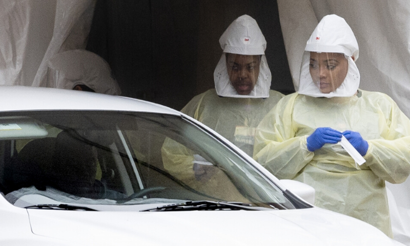 Medical personnel conduct drive-through testing for Covid-19 at Johns Hopkins Hospital in Baltimore, Maryland. — AFP/File